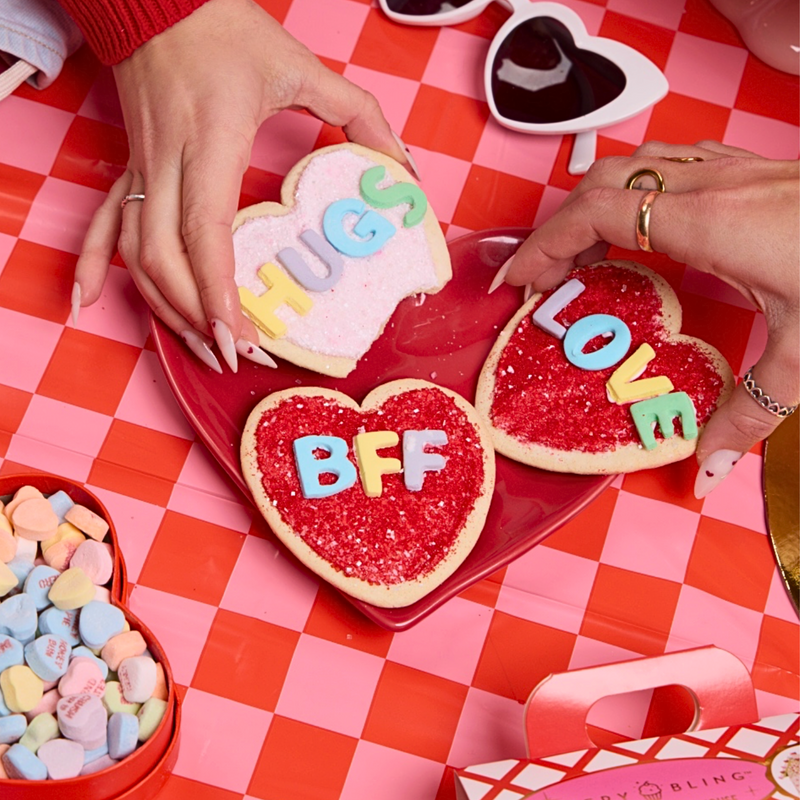 Bakery Bling Valentine's Day cookie decorating kit featuring heart-shaped pre-baked cookies, glittery sugar sprinkles, royal icing, and colorful edible letter decorations. Perfect for DIY Valentine’s activities, gifting, and holiday parties.